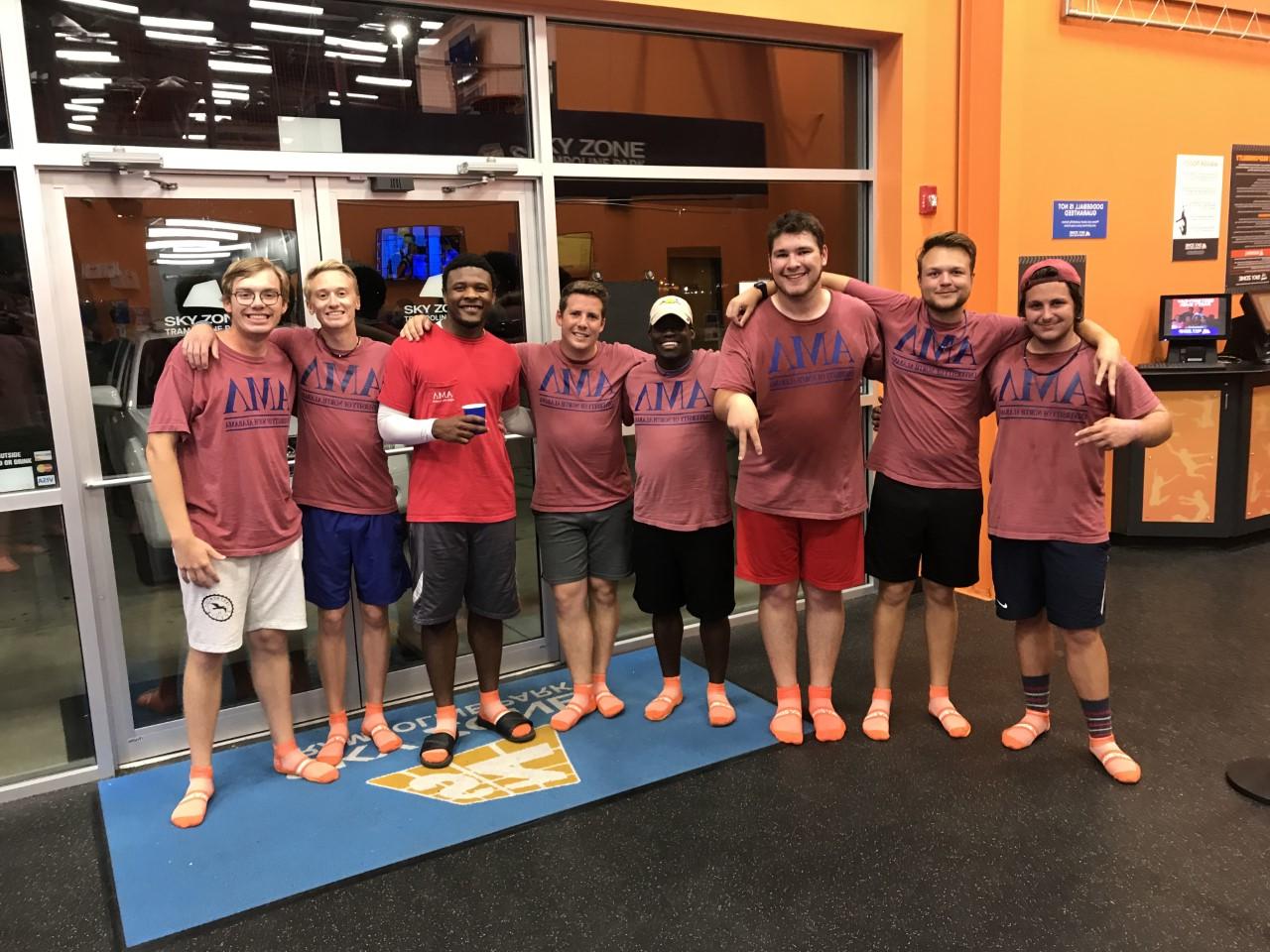 AML members in matching red shirts smiling in line together